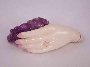 Lady's hand holding clump of grapes salt and pepper shakers