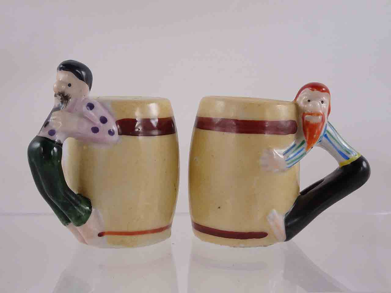 People hanging off sides of barrels salt and pepper shakers